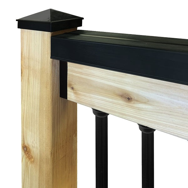 A close-up image of a handrail cover installed on a wooden handrail, showing the product in black color.